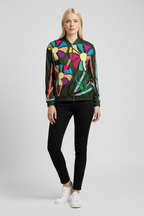 Woman wearing a colorful floral jacket with black pants on a white background