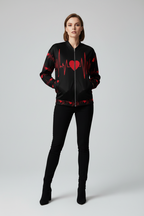 Woman wearing a black bomber jacket with red heart and pulse design on a gray background