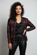 Woman wearing a black jacket with red patterns, black shirt, and black pants on a gray background