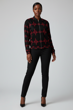 Person wearing a black and red patterned jacket with black pants on a white background