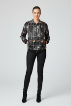 Person wearing a patterned jacket and black pants on a white background