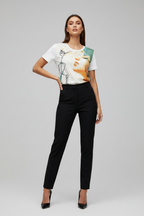 Woman wearing a graphic t-shirt and black pants on a gray background