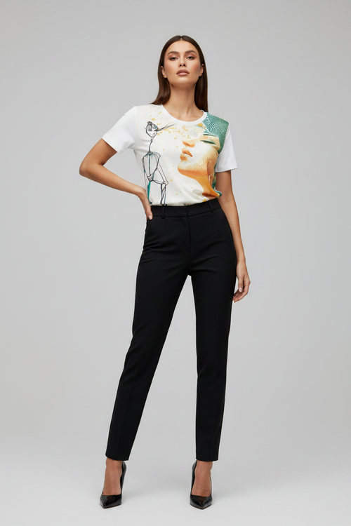 Woman wearing a graphic t-shirt and black pants on a gray background