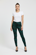 Woman wearing black patterned leggings and a white t-shirt on a white background