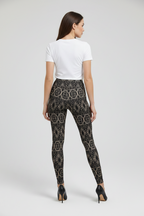Woman wearing black patterned leggings and a white top on a white background