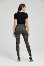 Woman wearing black patterned leggings and a black top on a white background