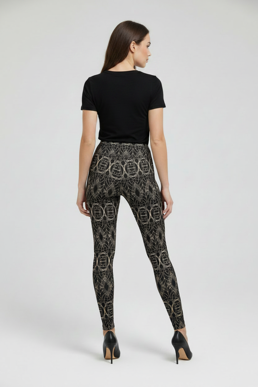 Woman wearing black patterned leggings and a black top on a white background