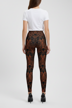 Person wearing black patterned leggings on a white background