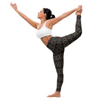 Yoga pose, demonstrating the flexibility and fit of the black and gold patterned yoga leggings.