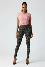 Woman wearing a pink t-shirt and patterned leggings on a white background