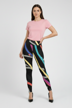Woman wearing a pink top and colorful leggings on a white background