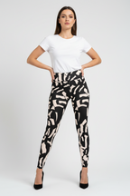 Woman wearing a white t-shirt and black and white patterned pants on a white background