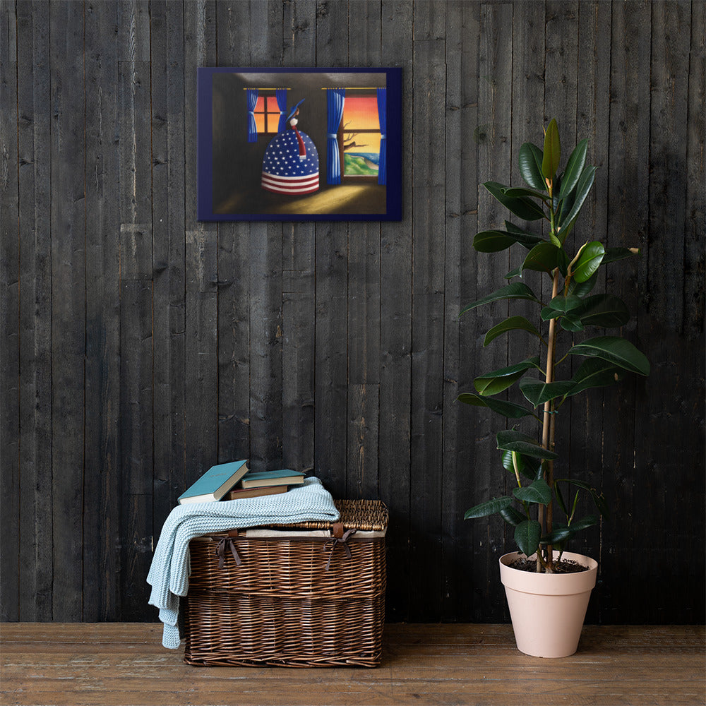 A framed art print depicting a whimsical figure in an American flag dress standing by a window, displayed on a dark wood-paneled wall above a wicker basket and next to a potted plant.