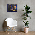 A framed wall art print depicting a patriotic American flag-themed still life hangs on a textured gray concrete wall above a white molded chair and next to a potted fiddle-leaf fig plant.