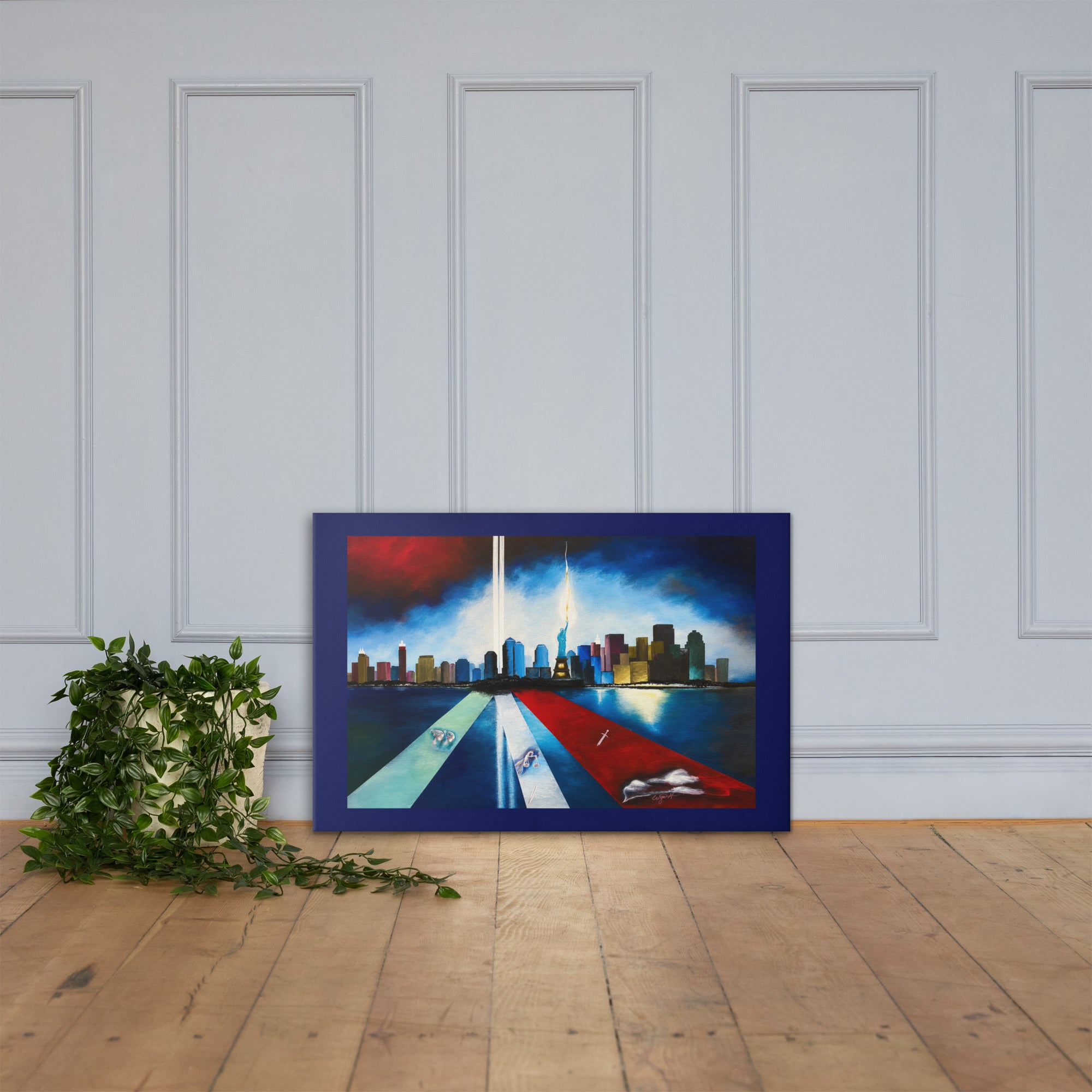 A framed canvas painting of the New York City skyline with the Twin Towers, displayed leaning against a white paneled wall on a light wood floor next to a green potted plant.