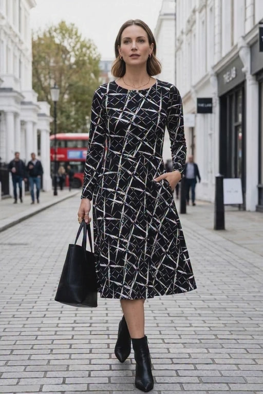 Elegant city style midi dress worn by confident female model outdoors