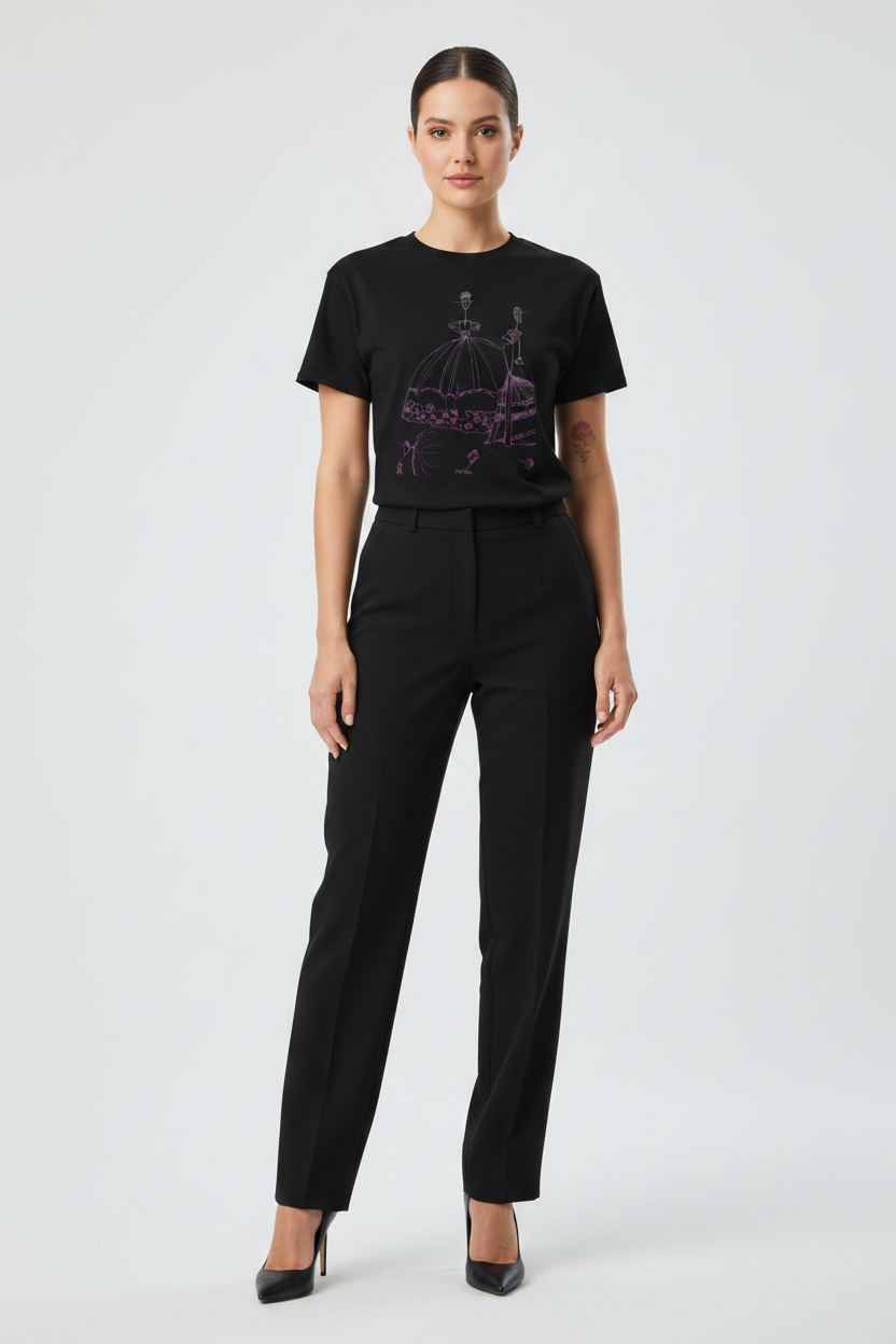 Woman wearing a black t-shirt with a graphic design and black pants on a white background