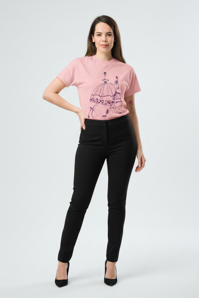 Woman wearing a pink t-shirt with a graphic design and black pants on a white background