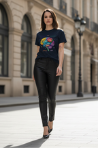 Woman wearing a black t-shirt with a colorful graphic and black leather pants standing on a city street.