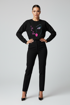 Woman wearing a black sweater with a graphic design on a gray background