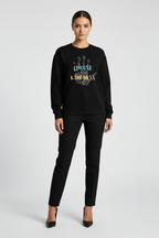 Woman wearing a black sweatshirt with a paw print design and text on a white background