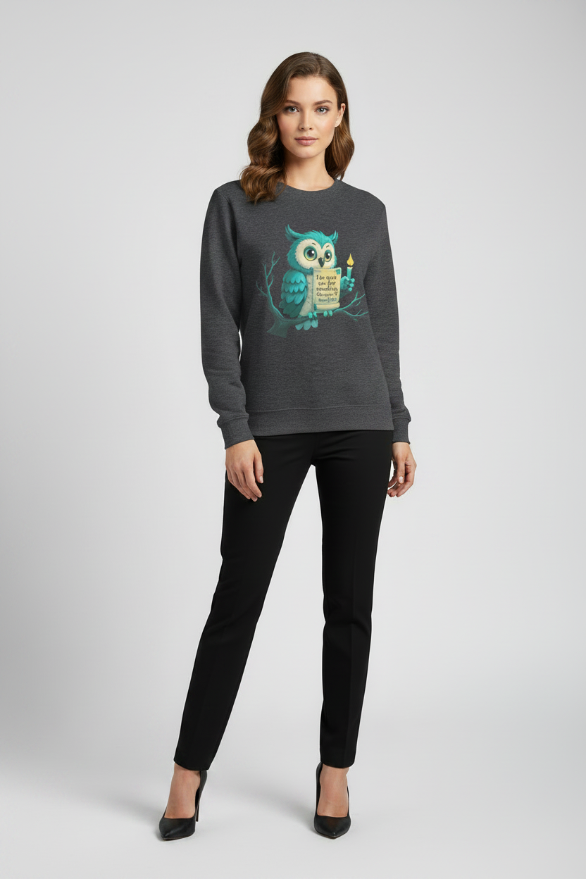 Woman wearing a dark gray sweatshirt with an owl design on a plain background