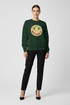 Woman wearing a green sweatshirt with a logo on a white background