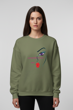 Person wearing a green sweatshirt with a face design on a plain background