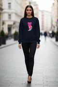 Woman wearing a black sweatshirt with a colorful graphic on a city street.
