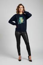 Woman wearing a navy blue sweater with an owl design on a gray background