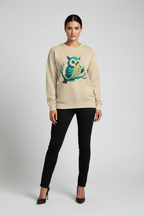 Woman wearing a beige sweater with an owl design on a plain background