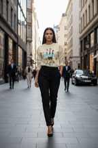 Woman walking down a city street wearing a graphic sweatshirt and black pants.