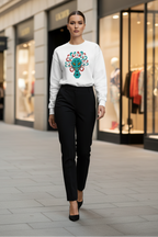 Woman wearing a white sweatshirt with a colorful alien design on a city street.