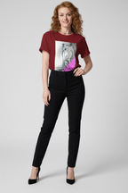 Woman wearing a burgundy t-shirt with a graphic design and black pants on a white background