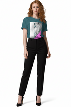 Woman wearing a teal t-shirt with a graphic design and black pants on a white background