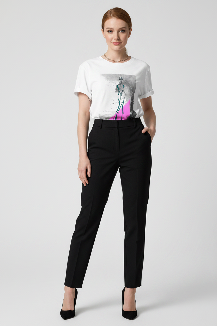 Woman wearing a white t-shirt with a graphic design and black pants on a white background