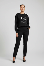 Woman wearing a black sweater with 'BE yourself' text on a gray background