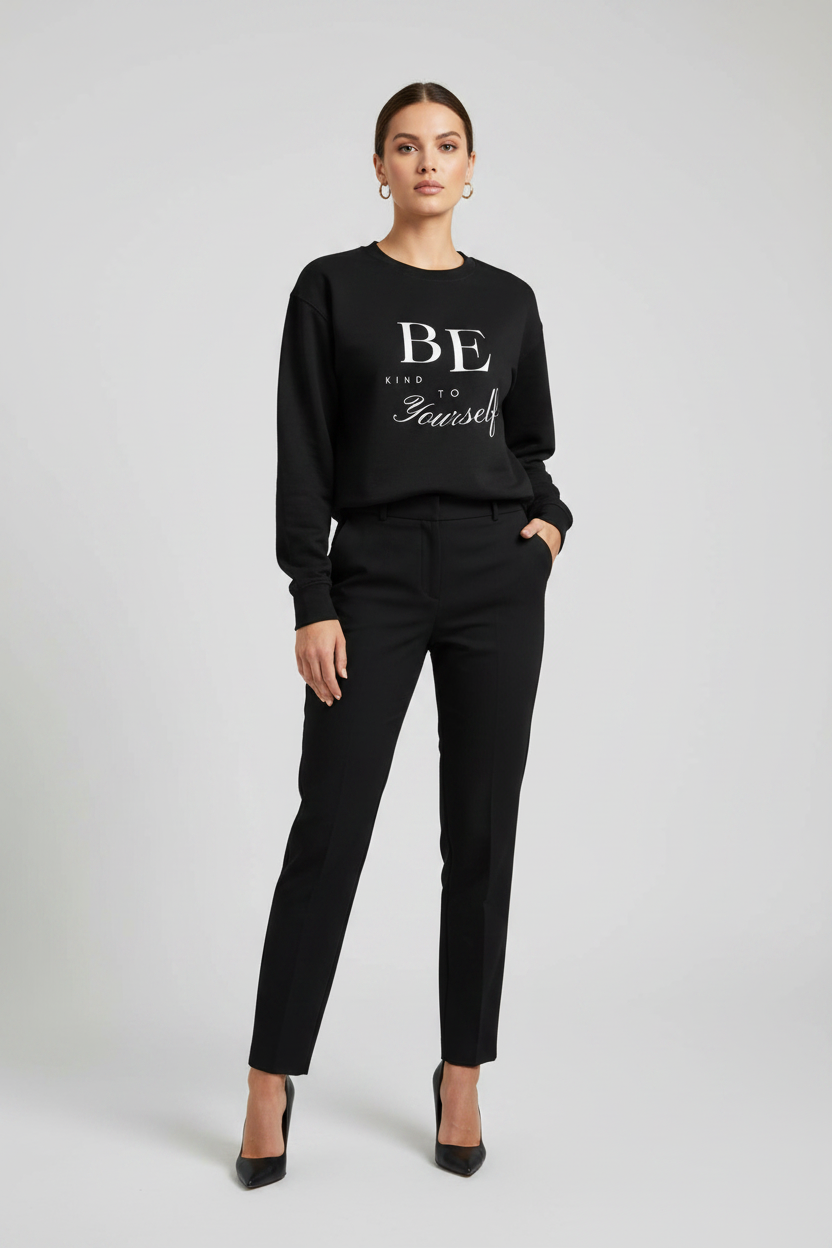 Woman wearing a black sweater with 'BE yourself' text on a gray background