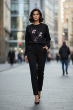 Woman wearing a black sweater with a graphic design in an urban setting