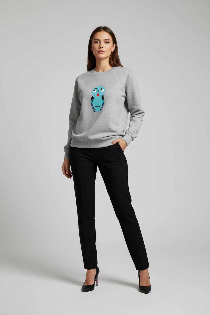 Woman wearing a gray sweatshirt with an owl design and black pants on a light gray background