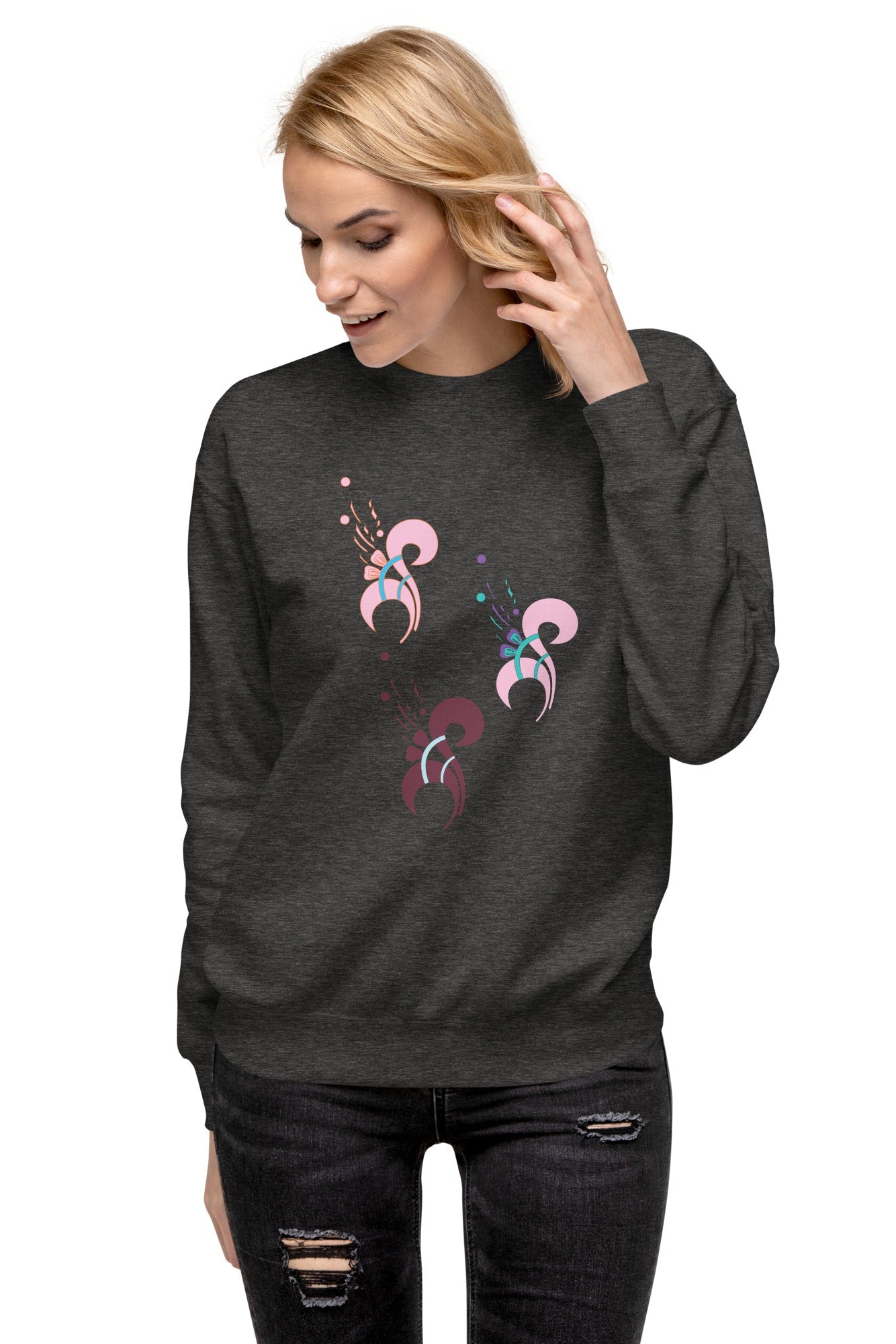 A woman wearing a gray sweatshirt with a floral print on the front, paired with ripped jeans.