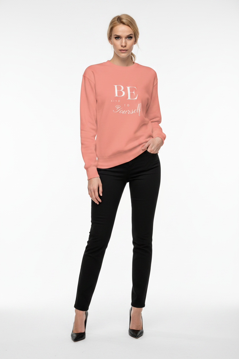 Woman wearing a pink sweatshirt with text and black pants on a white background