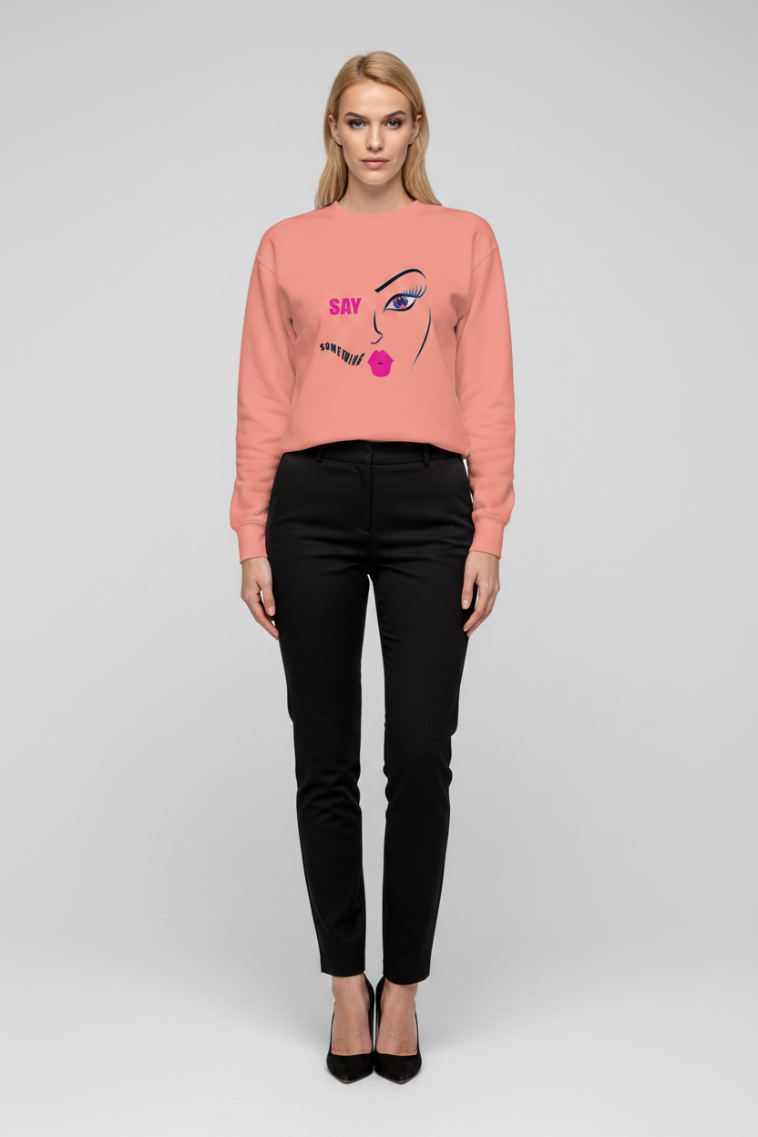 Woman wearing a pink sweatshirt with a graphic design on a plain background
