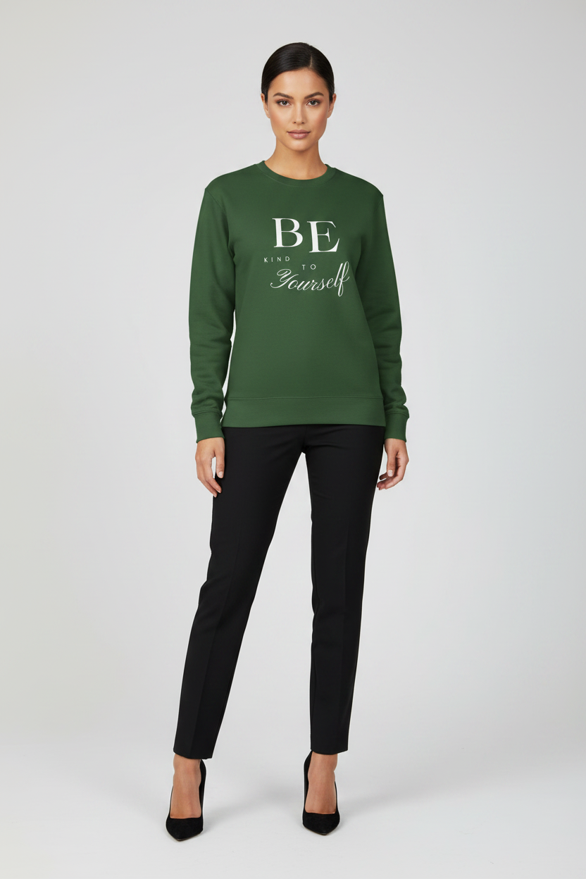 Woman wearing a green sweatshirt with text and black pants on a white background