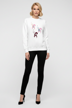 Woman wearing a white sweatshirt with a floral design and black pants on a white background