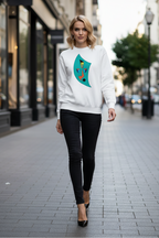 Woman wearing a white sweatshirt with a green graphic design on a city street.