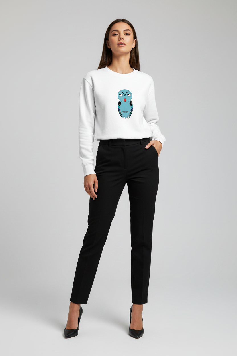Woman wearing a white sweater with a blue owl design and black pants on a light gray background