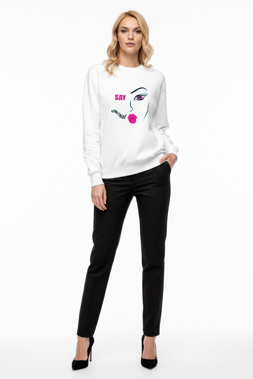 Woman wearing a white sweatshirt with a graphic design and black pants on a white background
