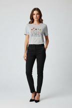 Woman wearing a white t-shirt with floral design and text, paired with black pants on a light gray background