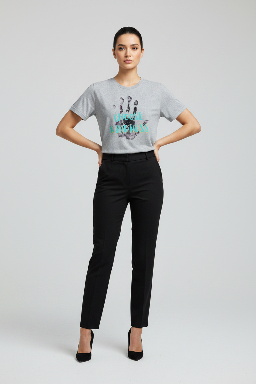 Woman wearing a gray t-shirt with a graphic design and black pants on a light gray background